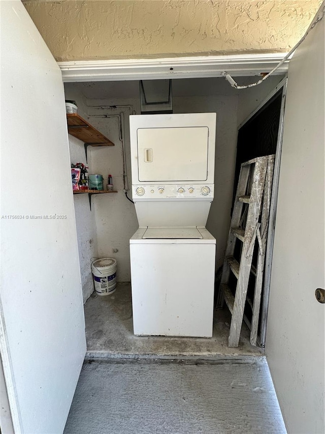 clothes washing area with stacked washing maching and dryer and laundry area