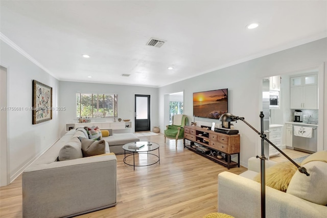 living room featuring light wood-type flooring, recessed lighting, visible vents, and ornamental molding