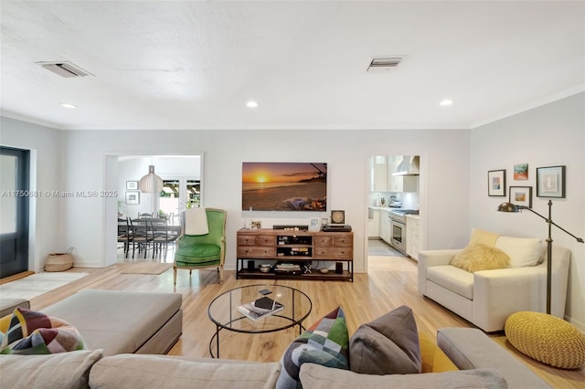 living area with recessed lighting, visible vents, and light wood finished floors