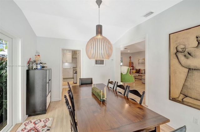 dining area with vaulted ceiling, visible vents, and light wood-style flooring