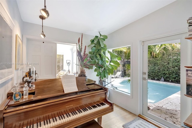 sitting room with vaulted ceiling and light wood-style flooring