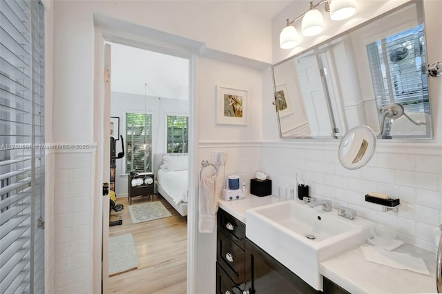 ensuite bathroom featuring tasteful backsplash, wood finished floors, vanity, and ensuite bathroom