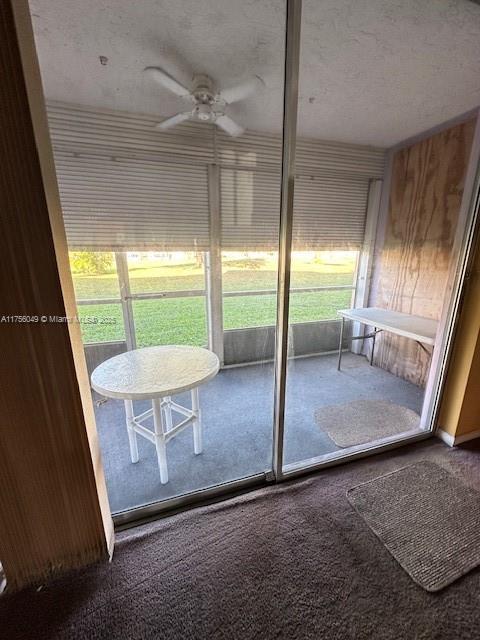 unfurnished sunroom featuring a ceiling fan