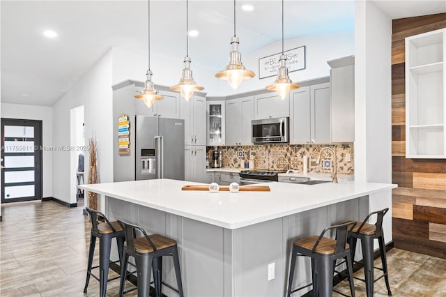 kitchen with stainless steel appliances, tasteful backsplash, a peninsula, and a kitchen breakfast bar