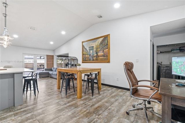 office space featuring baseboards, visible vents, vaulted ceiling, and wood finished floors