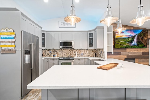 kitchen featuring vaulted ceiling, stainless steel appliances, a sink, and light countertops