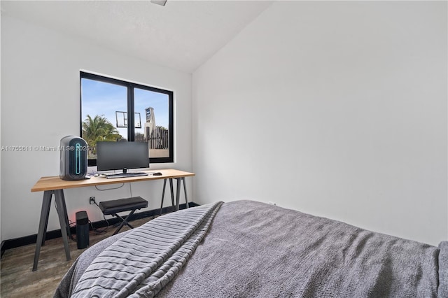 bedroom featuring vaulted ceiling, wood finished floors, and baseboards