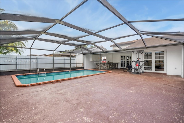 view of swimming pool with a lanai, a fenced in pool, a patio, and french doors