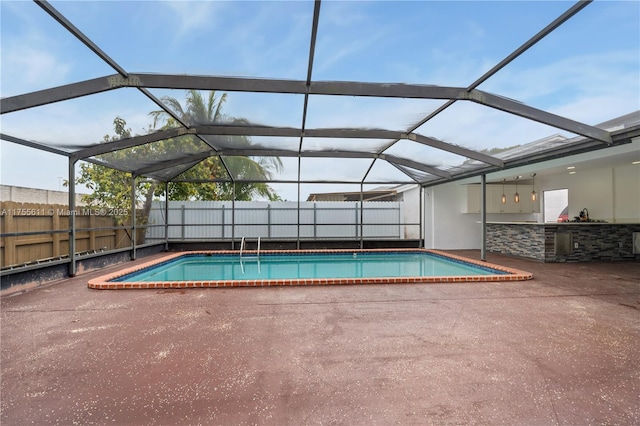 view of pool with a patio, glass enclosure, fence, and a fenced in pool