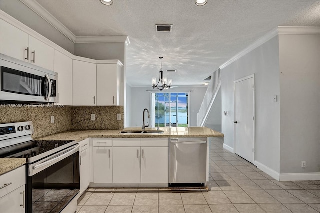 kitchen with a peninsula, stainless steel appliances, crown molding, white cabinetry, and a sink