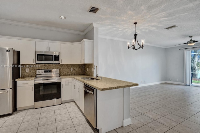 kitchen with a peninsula, visible vents, stainless steel appliances, and a sink