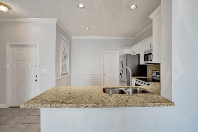 kitchen featuring light tile patterned floors, stainless steel appliances, a sink, white cabinetry, and ornamental molding