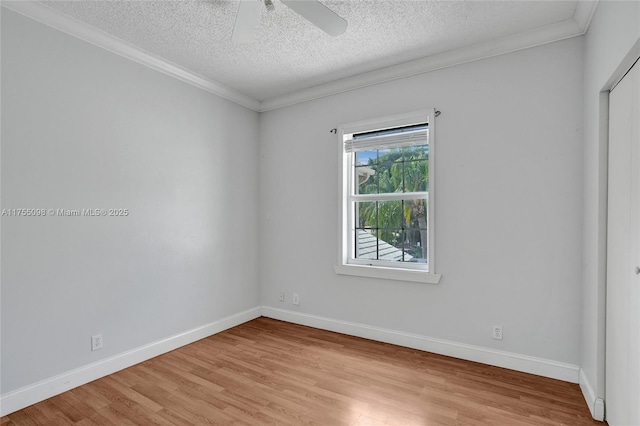 unfurnished room with ornamental molding, baseboards, a textured ceiling, and light wood finished floors