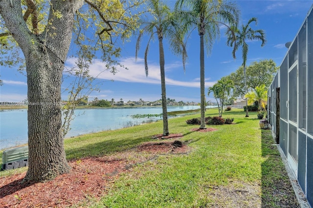 view of yard with a water view and a lanai