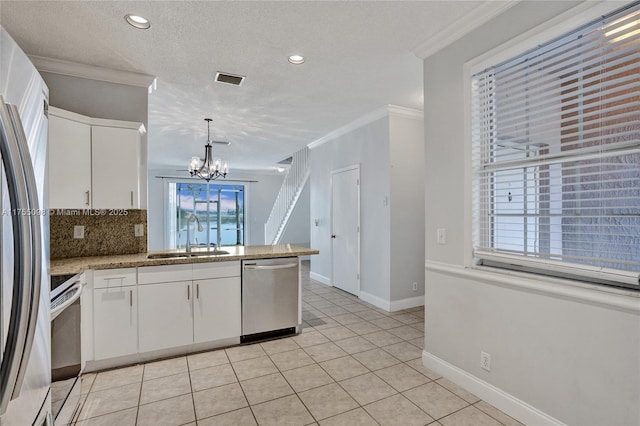 kitchen featuring appliances with stainless steel finishes, a sink, white cabinets, and crown molding