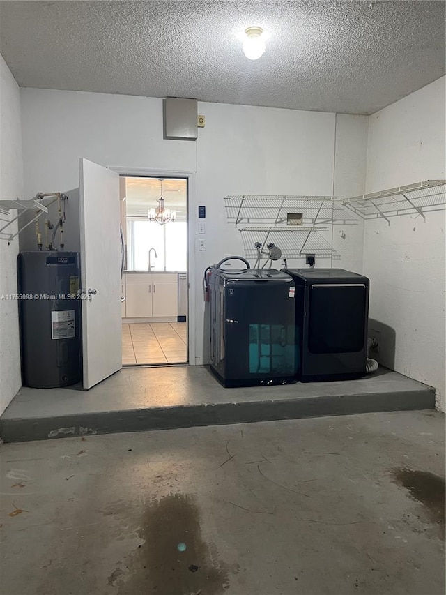 clothes washing area with washing machine and dryer, water heater, a sink, and a textured ceiling