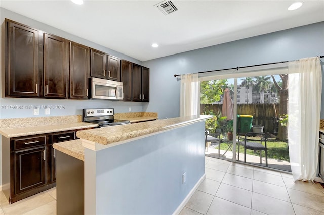 kitchen featuring dark brown cabinetry, visible vents, appliances with stainless steel finishes, light countertops, and recessed lighting