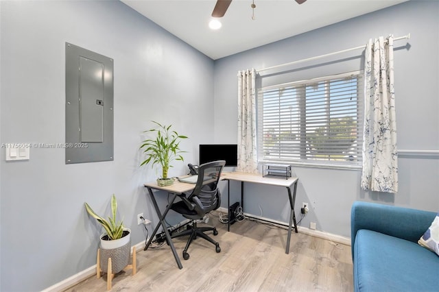 office featuring a ceiling fan, wood finished floors, electric panel, and baseboards