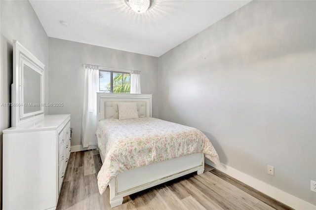 bedroom featuring light wood-style flooring and baseboards