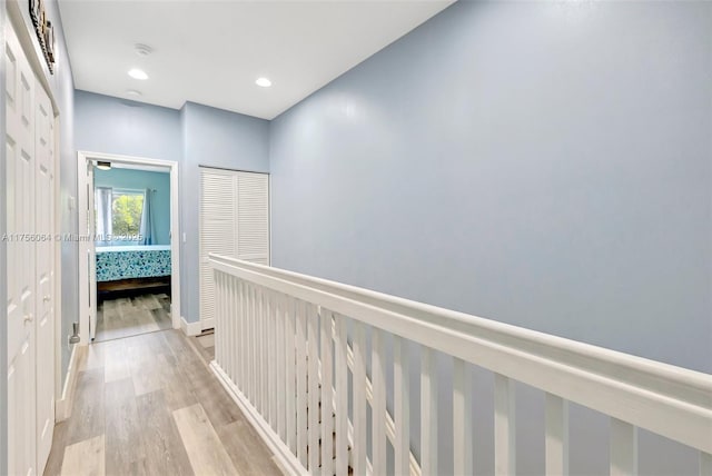 hallway with light wood-type flooring and recessed lighting