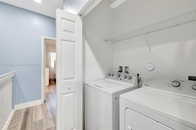 laundry area with light wood-style flooring, laundry area, washer and clothes dryer, and baseboards