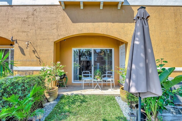 property entrance featuring a patio area and stucco siding