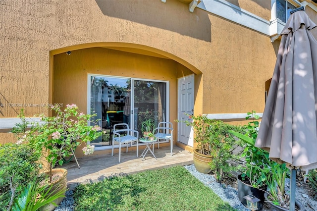 property entrance with a patio area and stucco siding