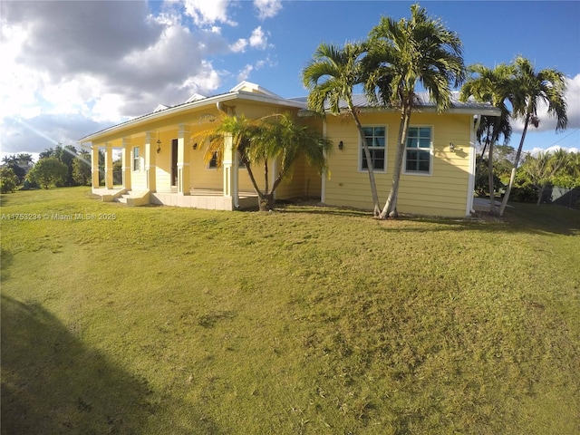 rear view of house featuring covered porch and a yard