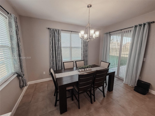 dining room with an inviting chandelier, light tile patterned flooring, and baseboards