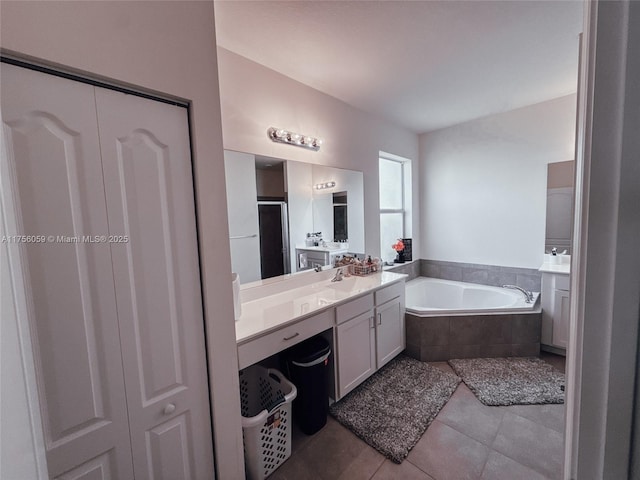 bathroom with a garden tub, vanity, a shower stall, and tile patterned floors