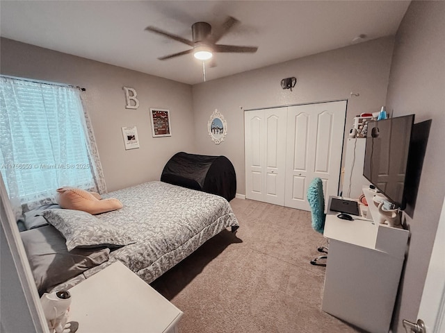 bedroom featuring light carpet, ceiling fan, and a closet