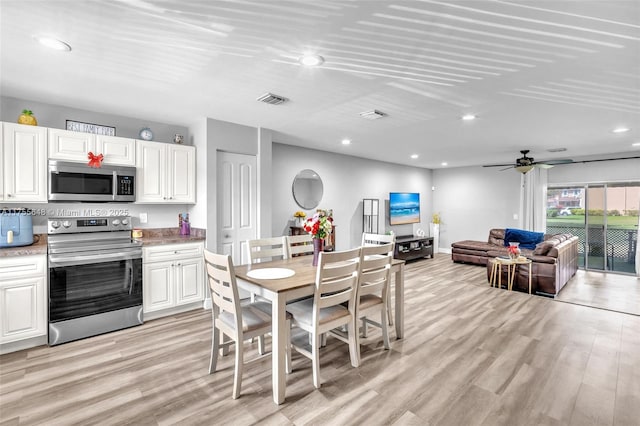 kitchen with appliances with stainless steel finishes, light wood-style flooring, visible vents, and white cabinetry