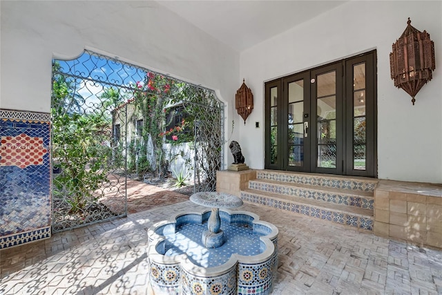 view of exterior entry featuring a patio and french doors