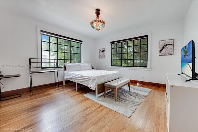 bedroom with baseboards and wood finished floors