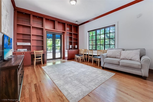 living area with light wood finished floors, ornamental molding, a wealth of natural light, and french doors