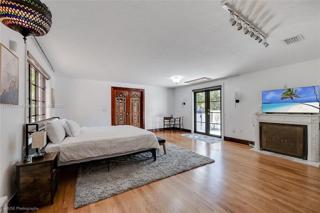 bedroom with french doors, wood finished floors, visible vents, and access to exterior