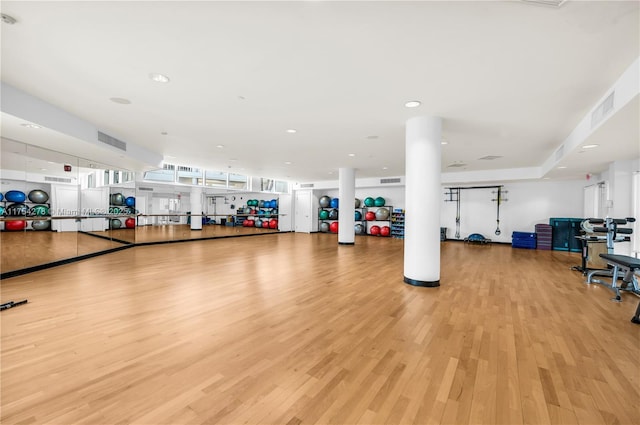 workout area with light wood-type flooring and visible vents