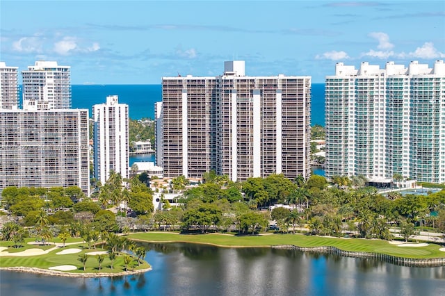 aerial view with golf course view, a water view, and a city view