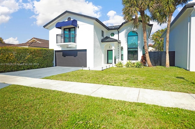 view of front facade with a balcony, a garage, driveway, stucco siding, and a front yard