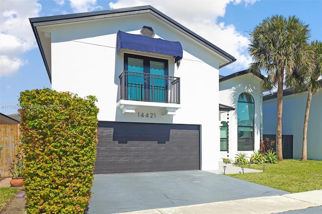 view of front of property featuring driveway, a balcony, an attached garage, and stucco siding