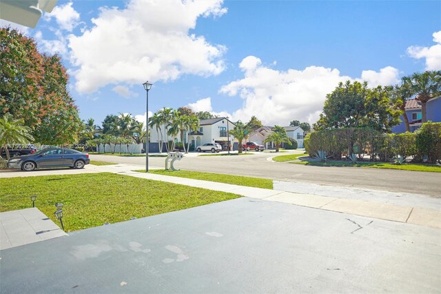 14421 SW 116th Ter, Miami, FL 33186 - view of concrete driveway with a residential view and street lighting