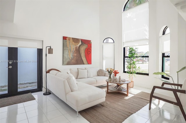 living room with tile patterned flooring and a high ceiling