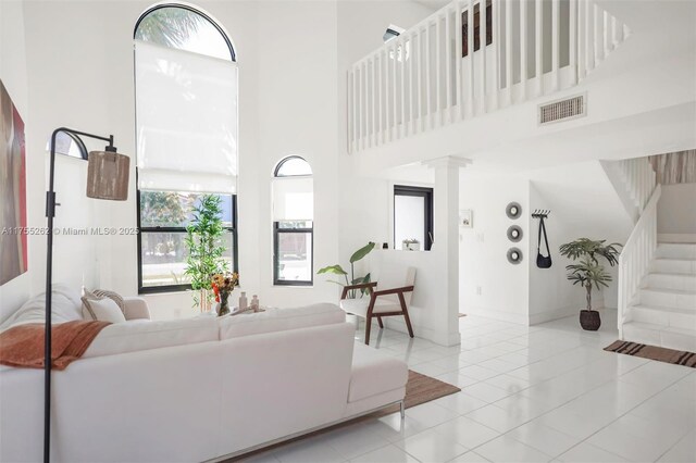 14421 SW 116th Ter, Miami, FL 33186 - living area featuring a high ceiling, healthy amount of natural light, stairway, and decorative columns