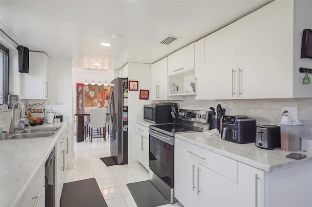 kitchen featuring visible vents, white cabinets, a sink, light tile patterned flooring, and black appliances