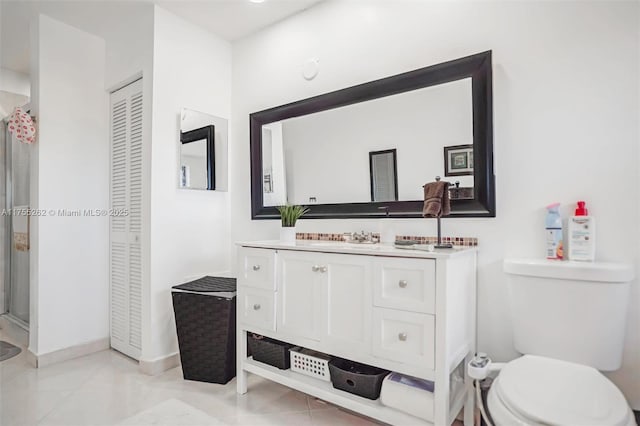 full bath with a closet, toilet, a stall shower, vanity, and tile patterned floors