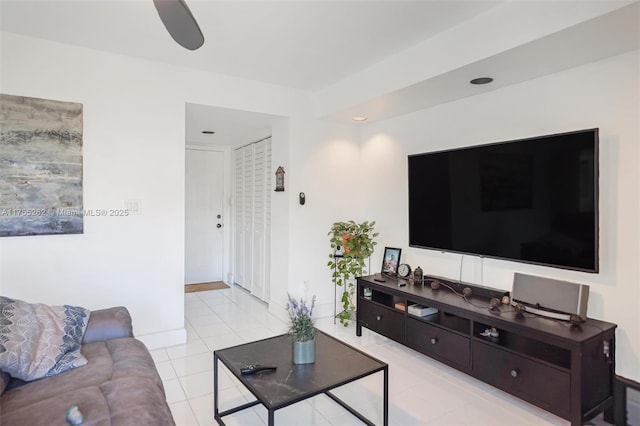 living room with a ceiling fan and light tile patterned flooring