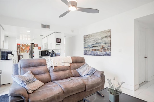 living room with light tile patterned floors, visible vents, and a ceiling fan