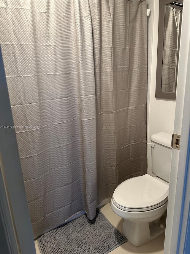 bathroom with a shower with curtain and toilet