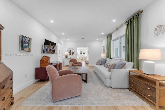 living area featuring recessed lighting, baseboards, and light wood finished floors