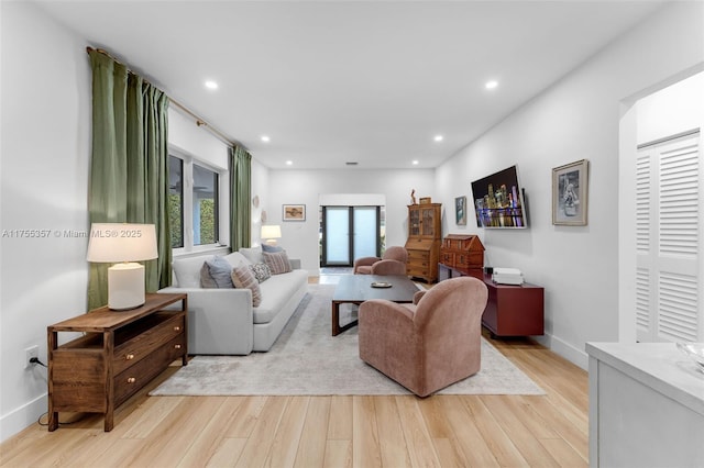 living room with recessed lighting, light wood-style flooring, and baseboards